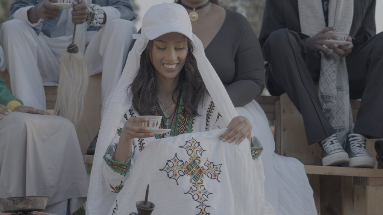 Performer holding a traditional coffee cup during filming