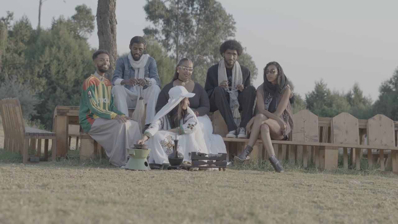 Bana Records cast seated together during the outdoor production