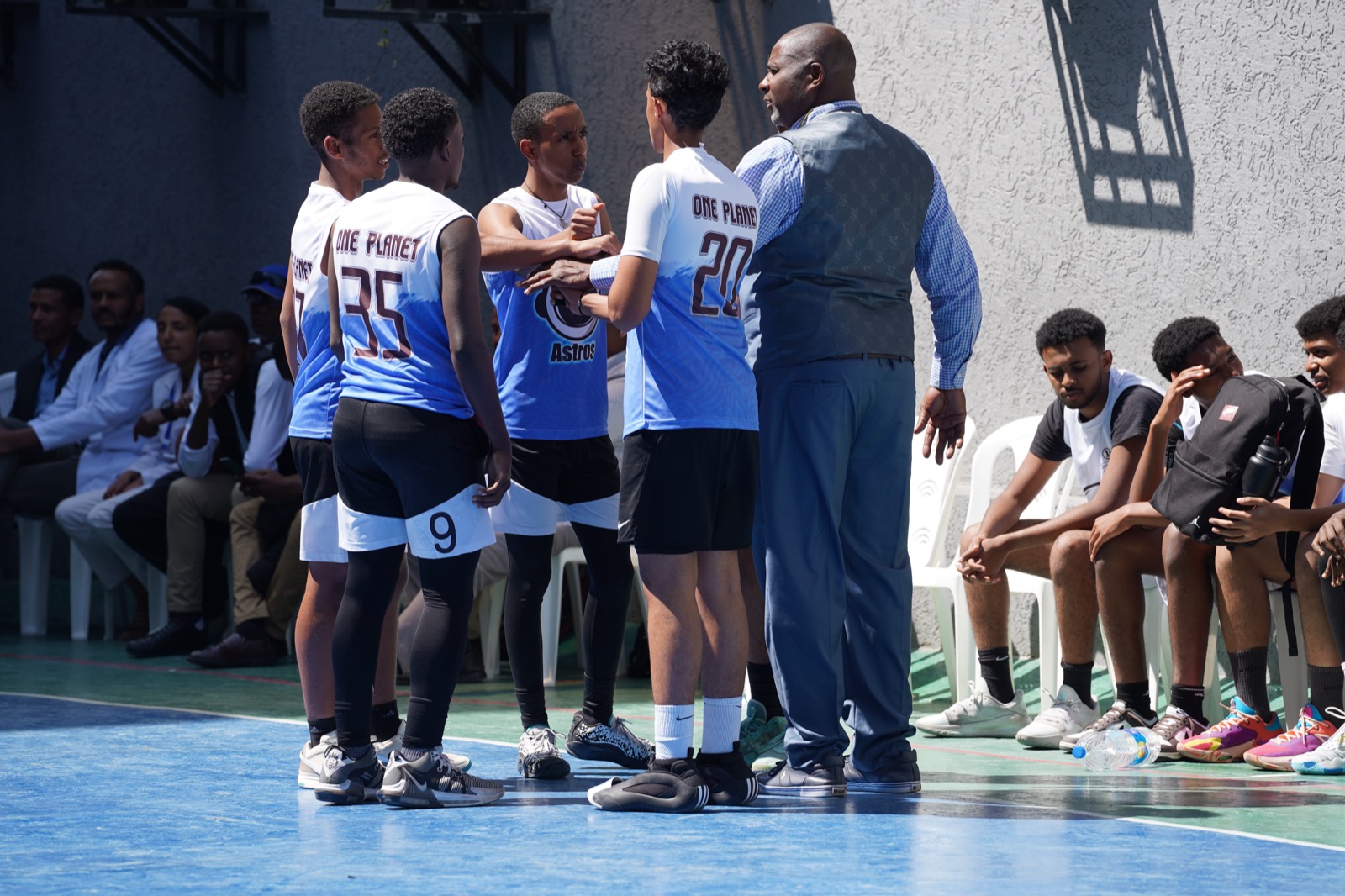 A coach speaking to youth basketball players during a Carlos Thornton program