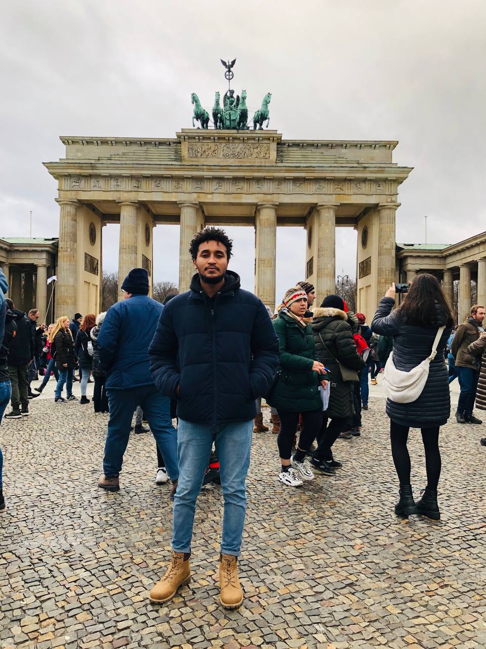 Dawit standing at the Brandenburg Gate in Berlin
